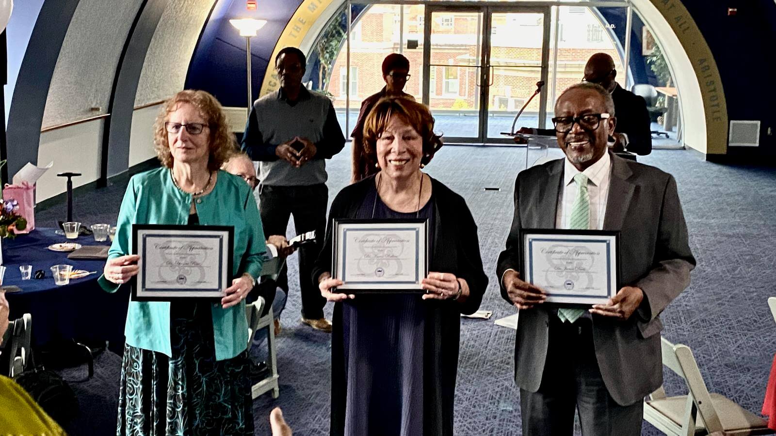 Doctors Davis, Poser and Wallace receiving commemorative plaques.